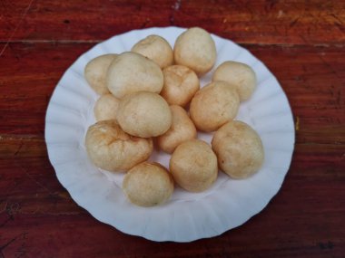 Yuvarlak kahverengi levrek krakerleri tahta bir masada beyaz bir konteynırda