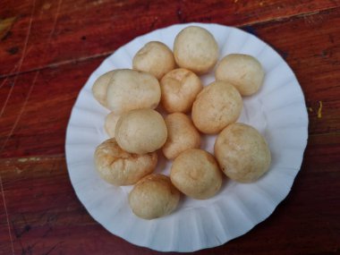 Yuvarlak kahverengi levrek krakerleri tahta bir masada beyaz bir konteynırda