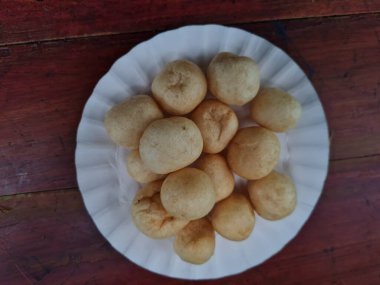 Yuvarlak kahverengi levrek krakerleri tahta bir masada beyaz bir konteynırda