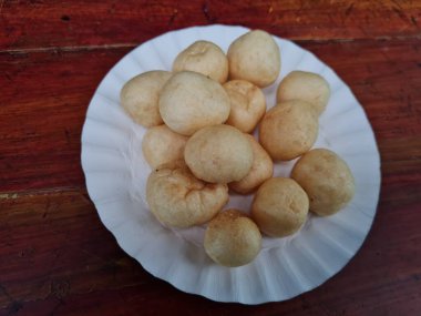 Yuvarlak kahverengi levrek krakerleri tahta bir masada beyaz bir konteynırda