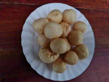 Yuvarlak kahverengi levrek krakerleri tahta bir masada beyaz bir konteynırda