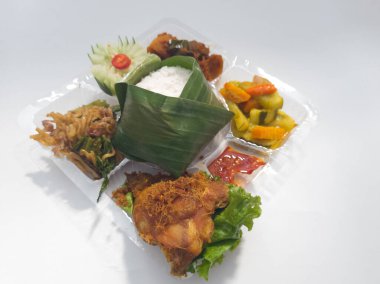 Beyaz pirinç, kızarmış tavuk, kızarmış erişte, salatalık dilimli kızarmış acı biber sosu.