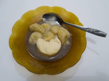 İçinde muz ve çikolata tabağında tatlı soslu kasava bandı bulunan Kolak.