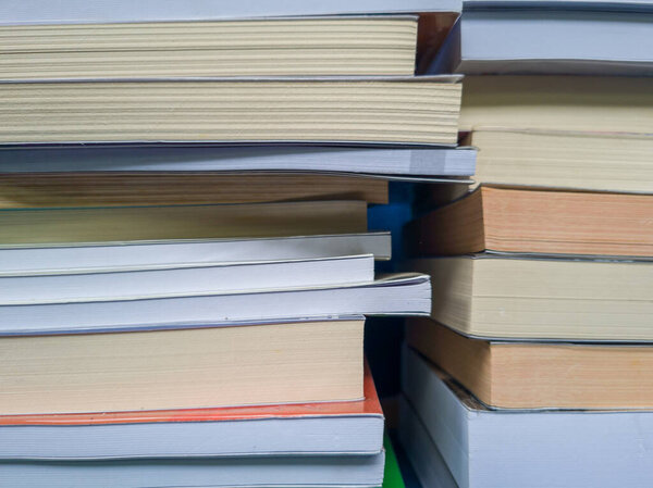 Абстрактный фактурный фон неровной стопки книг для чтения