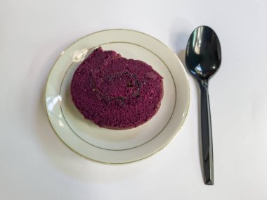 Beyaz tabakta ananas reçeli ile dolu çikolatalı kek ruloları.