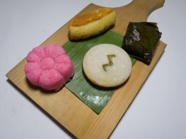 Dört pazar pastası beyaz apem, kırmızı apem, kusmuk keki ve muz yapraklarına sarılmış mendut kektir.