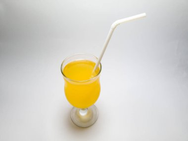 Beyaz arka planda, cam bardakta portakal aromalı içecek.