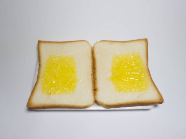 Beyaz bir kabın içinde ananas reçelli beyaz ekmek fotoğrafı.