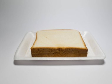 Beyaz bir kabın içindeki un ve diğer malzemelerden yapılmış ekmek.