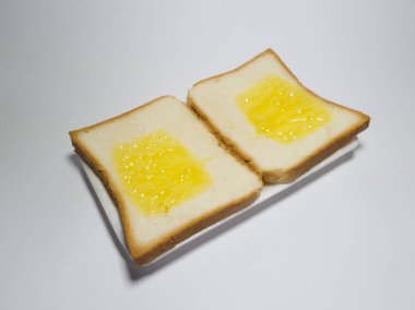 Beyaz bir kabın içinde ananas reçelli beyaz ekmek fotoğrafı.