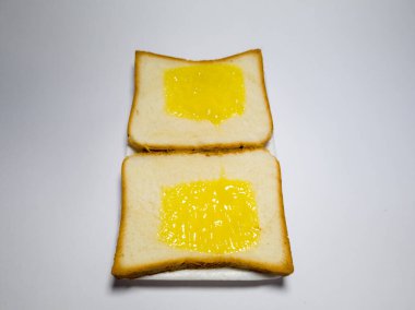 Beyaz bir kabın içinde ananas reçelli beyaz ekmek fotoğrafı.