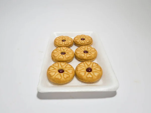 Biscuits filled with strawberry jam on the wood are perfect for a relaxing time