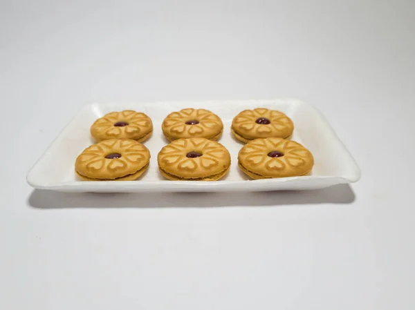 Biscuits filled with strawberry jam on the wood are perfect for a relaxing time