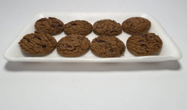 Un ve diğer malzemelerden yapılmış çikolatalı kurabiyeler beyaz arka planda.