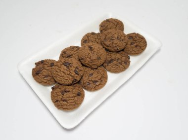 Un ve diğer malzemelerden yapılmış çikolatalı kurabiyeler beyaz arka planda.