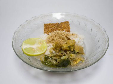 Endonezya 'dan Soto Ayam adlı bir yemek. Yanında da bir tabak tempeh.