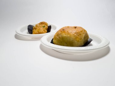 Beyaz bir kabın içinde risoles kek ve muz bolen