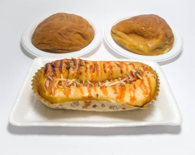 Kahverengi tatlı ekmek ve domates sosuyla doldurulmuş sosis.