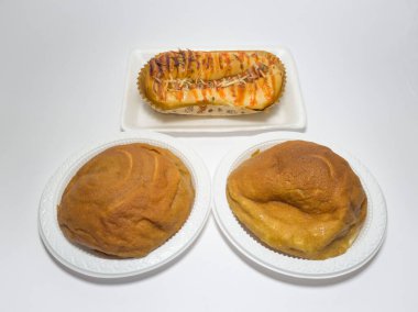 Kahverengi tatlı ekmek ve domates sosuyla doldurulmuş sosis.