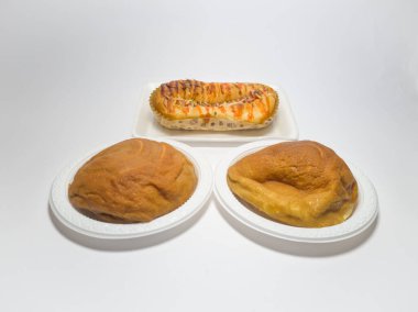 Kahverengi tatlı ekmek ve domates sosuyla doldurulmuş sosis.