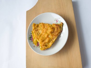 Beyaz arka planda beyaz bir tabakta omlet.