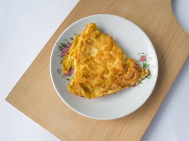 Beyaz arka planda beyaz bir tabakta omlet.