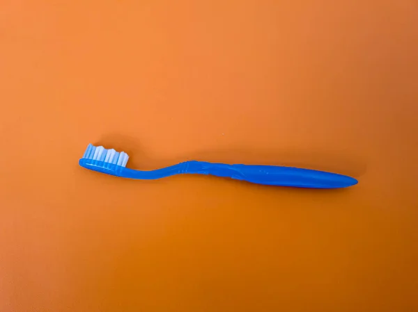 Niebieska Szczoteczka Zębów Pomarańczowym Tle — Zdjęcie stockowe