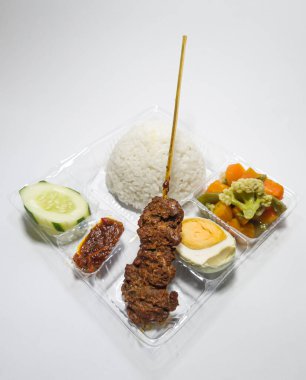 Biftek satay, capcay sebzesi, tuzlu yumurta ve dilimlenmiş salatalık ve kırmızı biber.