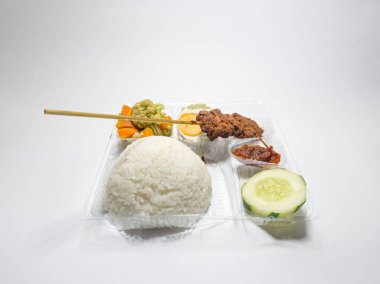 Biftek satay, capcay sebzesi, tuzlu yumurta ve dilimlenmiş salatalık ve kırmızı biber.