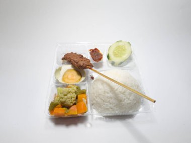 Biftek satay, capcay sebzesi, tuzlu yumurta ve dilimlenmiş salatalık ve kırmızı biber.