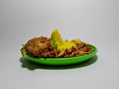 Kızarmış tavuklu pilav, dilimlenmiş tempeh, omlet ve salatalık dilimleri.