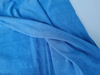 Mavi battaniye kumaşıyla beyaz kumaşın soyut desenli arka planı