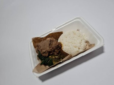 Baharatlı tavuk, yeşil biber sosu ve yeşil manyok yaprağı sebzeli Padang pilavı.