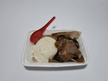 Baharatlı tavuk, yeşil biber sosu ve yeşil manyok yaprağı sebzeli Padang pilavı.