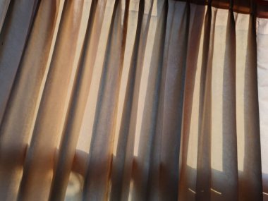 Abstract background textured brown window curtains exposed to sunlight so that shadows appear