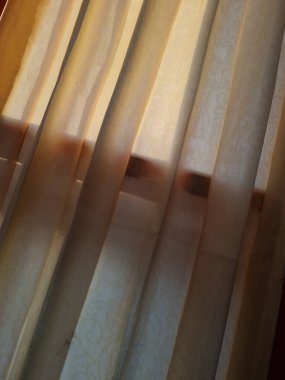 Abstract background textured brown window curtains exposed to sunlight so that shadows appear