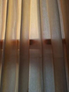 Abstract background textured brown window curtains exposed to sunlight so that shadows appear