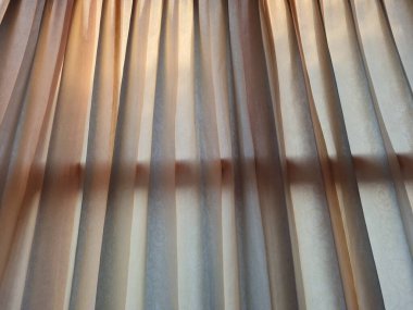 Abstract background textured brown window curtains exposed to sunlight so that shadows appear
