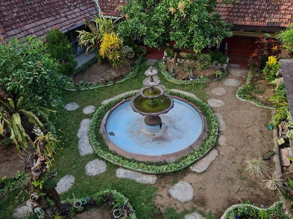 School garden with blue pond with plants around it