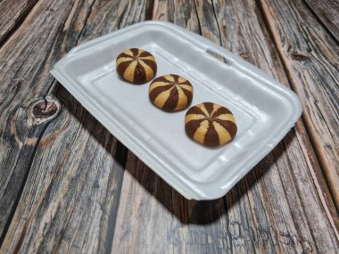 Chocolate flavored cookies in a white container