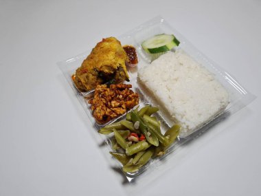 Typical dishes from Indonesia are mixed rice with fried chicken, fried chili sauce, stir-fried long beans and sliced cucumber