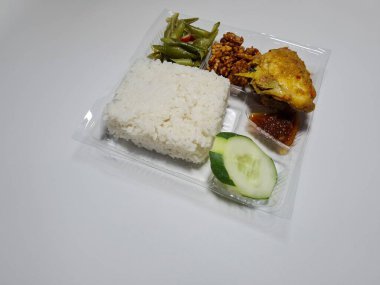 Typical dishes from Indonesia are mixed rice with fried chicken, fried chili sauce, stir-fried long beans and sliced cucumber
