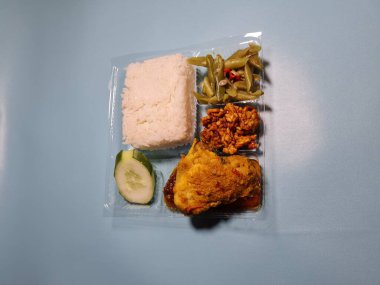 Typical dishes from Indonesia are mixed rice with fried chicken, fried chili sauce, stir-fried long beans and sliced cucumber