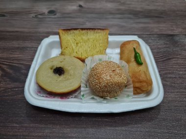 Snacks from the market consisting of mud cakes, apem cakes, spring rolls, steamed slices of bread, round bread filled with chocolate