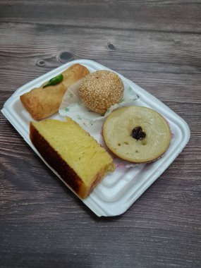 Snacks from the market consisting of mud cakes, apem cakes, spring rolls, steamed slices of bread, round bread filled with chocolate