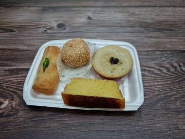 Snacks from the market consisting of mud cakes, apem cakes, spring rolls, steamed slices of bread, round bread filled with chocolate