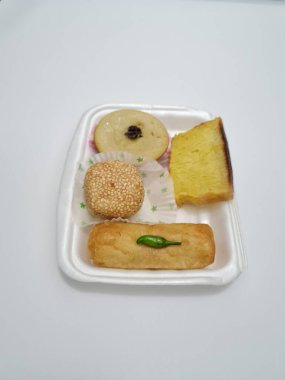 Snacks from the market consisting of mud cakes, apem cakes, spring rolls, steamed slices of bread, round bread filled with chocolate