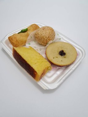 Snacks from the market consisting of mud cakes, apem cakes, spring rolls, steamed slices of bread, round bread filled with chocolate