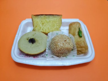Snacks from the market consisting of mud cakes, apem cakes, spring rolls, steamed slices of bread, round bread filled with chocolate