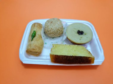 Snacks from the market consisting of mud cakes, apem cakes, spring rolls, steamed slices of bread, round bread filled with chocolate